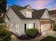 Exterior home view highlighting architectural details, a two-car garage, and attractive landscaping at 103 Aisling Ct, Cary, NC 27513