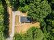 Overhead shot of a home showcasing its architectural design, surrounded by lush greenery and gravel driveway at 1065 Shuford Rd, Wake Forest, NC 27587