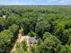 Aerial perspective of house enveloped by mature trees, revealing its location and surrounding landscape at 1065 Shuford Rd, Wake Forest, NC 27587