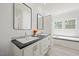 Bright bathroom featuring double sinks, a large tub, and modern fixtures at 1065 Shuford Rd, Wake Forest, NC 27587