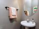Cozy half-bathroom features pedestal sink, oval mirror, and elegant towel rack at 1103 Mallory Ln, Durham, NC 27713