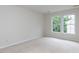 Empty bedroom with neutral carpet and paint and abundant natural light from two windows at 1103 Mallory Ln, Durham, NC 27713