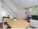 Bright dining space with a wooden table, comfortable seating, and an open view of the staircase and living area at 1103 Mallory Ln, Durham, NC 27713