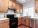 This kitchen features wooden cabinets, stainless steel appliances, and a large window with a view at 1103 Mallory Ln, Durham, NC 27713