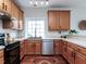 Functional kitchen featuring wooden cabinets, stainless steel appliances, and a window over the sink for natural light at 1103 Mallory Ln, Durham, NC 27713