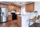 Well-lit kitchen featuring wooden cabinetry, modern appliances, and a cozy breakfast bar with seating at 1103 Mallory Ln, Durham, NC 27713