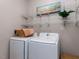 A laundry room with a washer, a dryer, metal shelving and a painting at 1103 Mallory Ln, Durham, NC 27713
