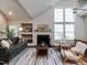 Inviting living room with a cozy fireplace, a stylish green sofa, and plenty of natural light at 1103 Mallory Ln, Durham, NC 27713