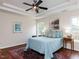 A main bedroom with a tray ceiling, windows, a large bed and side tables with lamps at 1103 Mallory Ln, Durham, NC 27713