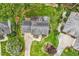 Aerial top-down view of home with landscaped backyard, patio, mature trees, and circular driveway at 1120 Colonial Club Rd, Wake Forest, NC 27587