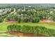 An aerial view of a lush, wooded neighborhood bordering a manicured golf course at 1120 Colonial Club Rd, Wake Forest, NC 27587