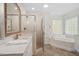 A well-lit bathroom features a separate shower and tub, decorative tile, and is equipped with a large vanity at 1120 Colonial Club Rd, Wake Forest, NC 27587