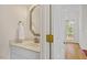 A well-lit half bath with a decorative mirror, a marble-topped vanity, and an adjacent room visible through an open door at 1120 Colonial Club Rd, Wake Forest, NC 27587