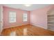 Bright bedroom with hardwood floors, large windows, and custom built-in shelving at 1120 Colonial Club Rd, Wake Forest, NC 27587