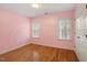 Comfortable bedroom featuring hardwood floors, soft pink walls, and natural light at 1120 Colonial Club Rd, Wake Forest, NC 27587