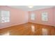 A sunny bedroom features wood floors, two windows, and fresh paint creating a calm and welcoming atmosphere at 1120 Colonial Club Rd, Wake Forest, NC 27587
