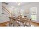 Bright dining room featuring a wood table, staircase, chandelier, and sunlit windows at 1120 Colonial Club Rd, Wake Forest, NC 27587