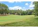 Scenic view of a lush green golf course with trees and beautiful homes in the distance at 1120 Colonial Club Rd, Wake Forest, NC 27587