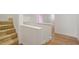 Bright hallway featuring wood floors, staircase with tan carpet steps and neutral color scheme at 1120 Colonial Club Rd, Wake Forest, NC 27587