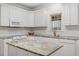 Charming kitchen featuring white cabinets, a kitchen island with granite countertops, and stainless steel appliances at 1120 Colonial Club Rd, Wake Forest, NC 27587