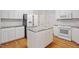 Bright kitchen boasting white cabinets, an island with marble countertops and stainless steel appliances at 1120 Colonial Club Rd, Wake Forest, NC 27587
