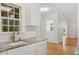 Well-lit kitchen with white cabinets, a sink, and a view to the outdoors through the windows at 1120 Colonial Club Rd, Wake Forest, NC 27587