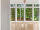 Bright sunroom featuring hardwood floors, a cross decoration, and a wall of windows overlooking lush greenery at 1120 Colonial Club Rd, Wake Forest, NC 27587