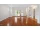 Large open concept living room with gleaming hardwood floors, columns, and lots of windows at 1120 Colonial Club Rd, Wake Forest, NC 27587