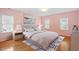 A staged main bedroom with wood floors, a large bed, a rug, bedside lamps, and neutral-toned walls and decor at 1120 Colonial Club Rd, Wake Forest, NC 27587