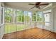 Screened porch with wood floors, ceiling fan, and views of the lush backyard at 1120 Colonial Club Rd, Wake Forest, NC 27587