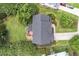 Aerial view of a home with a dark roof, surrounded by a green lawn, mature trees, and a fenced backyard at 1153 Litchborough Way, Wake Forest, NC 27587