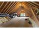 Unfinished attic featuring exposed rafters and beams with a window at 1153 Litchborough Way, Wake Forest, NC 27587