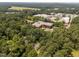 An aerial shot shows the neighborhood and a home nestled in a lush, green, and mature forest at 116 Justice St, Chapel Hill, NC 27516