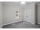 Bedroom with gray carpet, a window, double closet doors and light gray walls at 116 Justice St, Chapel Hill, NC 27516