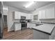 Bright kitchen boasts white cabinets, stainless steel appliances, tile backsplash, and ample counter space at 116 Justice St, Chapel Hill, NC 27516