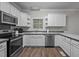 Bright kitchen features stainless appliances, wooden floors, and sleek white cabinets at 116 Justice St, Chapel Hill, NC 27516