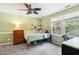 This cozy bedroom features a stylish ceiling fan, soft green walls, and bright natural light from the window at 11619 Appaloosa W Run, Raleigh, NC 27613