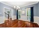 Dining room features hardwood floors, modern chandelier, and windows with blue curtains at 11619 Appaloosa W Run, Raleigh, NC 27613