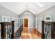 Upper hallway with hardwood floors, natural light, and decorative railing to living room at 11619 Appaloosa W Run, Raleigh, NC 27613