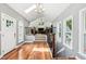 Bright hallway with hardwood floors, white walls, and iron railing leading to the living room at 11619 Appaloosa W Run, Raleigh, NC 27613