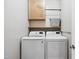 Well-lit laundry room with wooden cabinets and modern, white LG washer and dryer at 11619 Appaloosa W Run, Raleigh, NC 27613