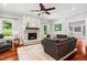 Inviting living room showcasing a brick fireplace, wood floors, and comfortable dark gray seating at 11619 Appaloosa W Run, Raleigh, NC 27613