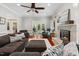 Bright living room with a cozy fireplace, plush rug, and comfortable seating illuminated by a ceiling fan at 11619 Appaloosa W Run, Raleigh, NC 27613