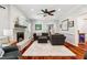 Cozy living room features a brick fireplace, ceiling fan, wood floors, and comfortable dark gray seating at 11619 Appaloosa W Run, Raleigh, NC 27613