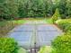 Aerial view of tennis and basketball courts surrounded by lush greenery at 11619 Appaloosa W Run, Raleigh, NC 27613