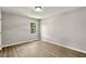 Bright bedroom featuring modern gray walls and new wood-look laminate flooring and window at 117 S Woodstone Dr, Archer Lodge, NC 27527