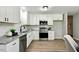 Stylish kitchen featuring white cabinetry, granite countertops and modern stainless appliances at 117 S Woodstone Dr, Archer Lodge, NC 27527