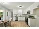 Modern kitchen with white cabinets, stainless steel appliances, and an adjacent dining area at 117 S Woodstone Dr, Archer Lodge, NC 27527