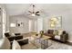 Bright living room featuring hardwood floors, neutral decor, a ceiling fan, and stylish furnishings at 117 S Woodstone Dr, Archer Lodge, NC 27527