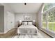 Serene main bedroom with large windows, a ceiling fan, and neutral decor for a calming atmosphere at 117 S Woodstone Dr, Archer Lodge, NC 27527